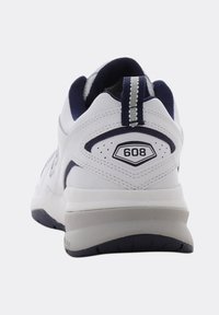White athletic sneaker with navy blue accents, pull tab on heel, and "608" label, shown from the rear on a white background.