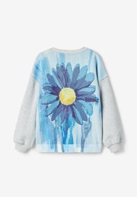 Felpa grigia chiara con una grande grafica di una margherita blu su uno sfondo blu sfumato. Polsini e orlo a coste. Texture morbida, design casual.