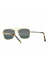 Occhiali da sole in metallo dorato con lenti quadrate, tinta verde scuro e dettagli in tartaruga sulle asticelle. Design leggero e slanciato.
