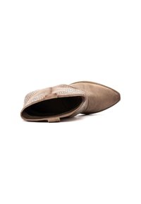 Botín de ante beige con diseño de punta afilada, que cuenta con una correa decorativa de cuentas de plata a lo largo del lateral.