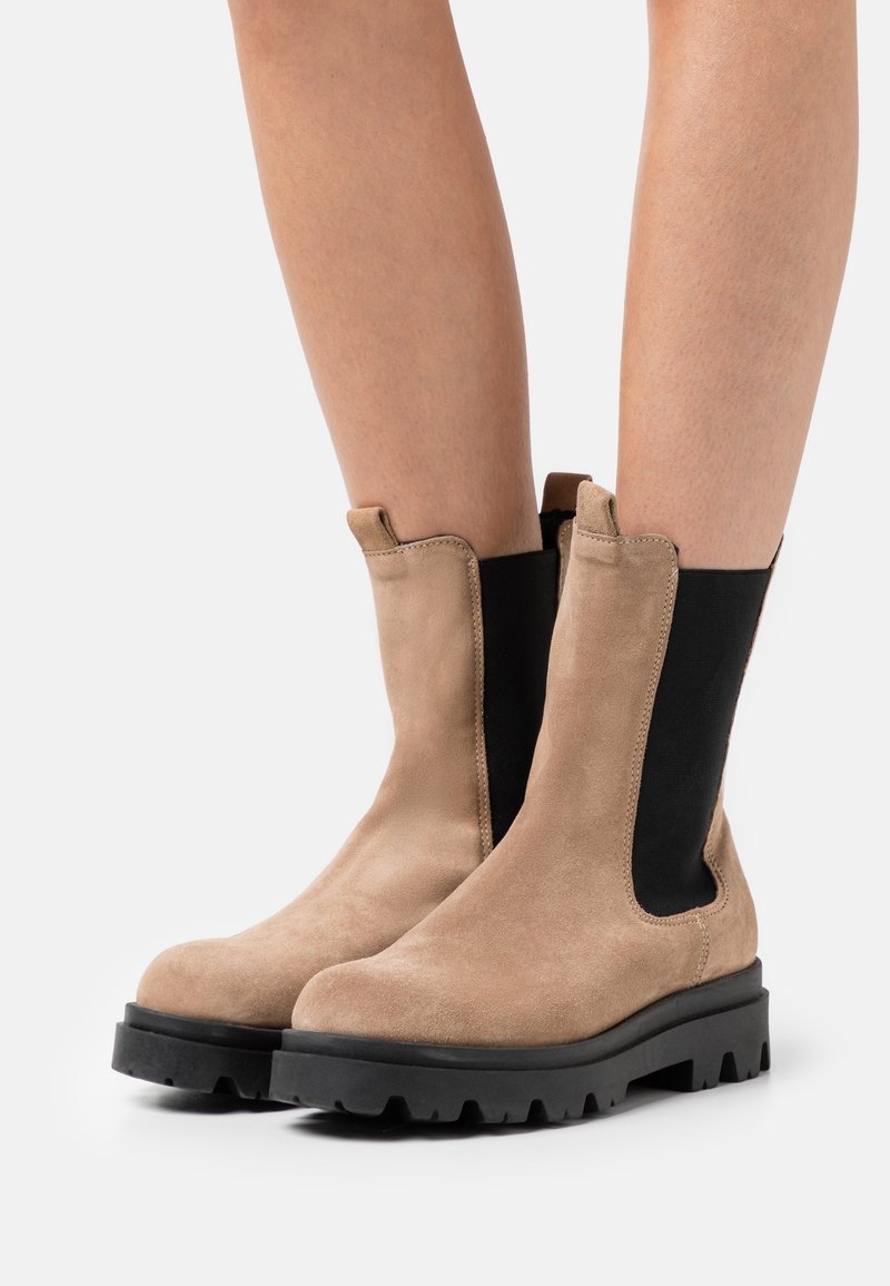 Beiga mockaskinn ankle boots med svarta elastiska sidopaneler, rund tå och gummitåsula; enkel, funktionell design.
