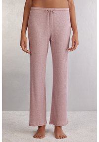 Ribbstickade, mjuka rosa loungebyxor med dragsko i midjan och en avslappnad passform. Har en rak ben design och subtil textur.