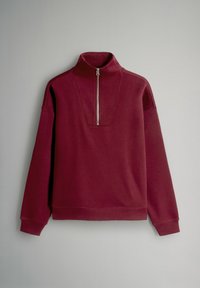Sudadera burdeos con cuello de media cremallera, que presenta un diseño estructurado y una textura suave, mangas largas y puños y dobladillo acanalados.