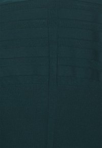 Strickstoff in Türkis mit horizontaler Rippstruktur, der in der Mitte einer glatten Naht verläuft. Weiches Material mit leichtem Glanz.