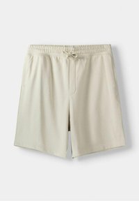 Beige šortky po kolena vyrobené z měkké látky s elastickým pasem, šňůrkou na stažení a bočními kapsami. Hladký povrch, bez vzorů.