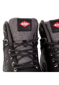 Czarne wysokie buty za kostkę z szarymi tekstylnymi akcentami, teksturowanym kołnierzem i metalowymi elementami. Posiadają sznurowany design oraz metki firmowe.