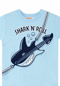 Ljusblå t-shirt med en grafisk bild av en haj som spelar en svart gitarr, med texten "SHARK 'N' ROLL" och bubbelaccenter i marinblått.