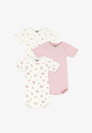 Drie korte mouwen baby-rompers: één effen lichtroze met strik, één wit met een klein geel bloemmotief en één wit met een roze bloemmotief.