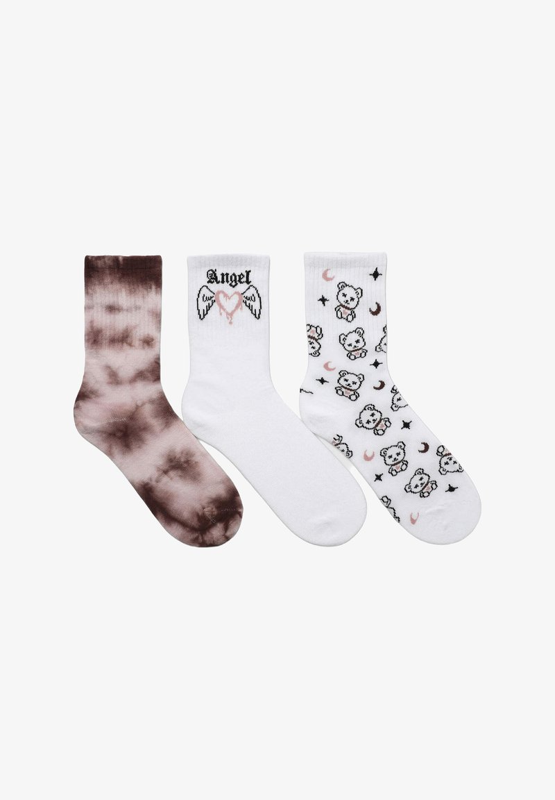 Tre paia di calze: a sinistra in tie-dye marrone, al centro bianche con il testo "Angel" e un grafico a forma di cuore, a destra bianche con motivi di orsetti neri e rosa.