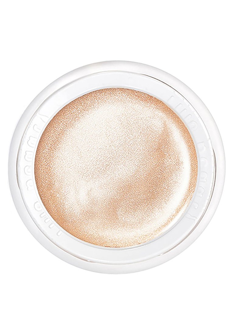 Un contenant rond et blanc renferme un enlumineur crémeux et scintillant dans une teinte champagne clair. La surface a une texture lisse avec un éclat subtil.