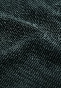 Texturovaná tkanina v tmavě zelené barvě, s výrazným žebrovaným vzorem a měkkou, sametovou texturou. Ideální pro oděvy nebo čalounění.