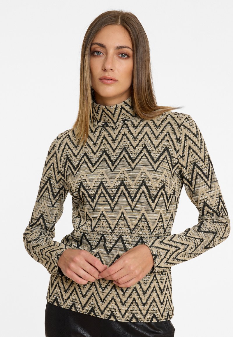 Musteriertes Langarm-Turtleneck-Top in Beige und Schwarz. Verfügt über ein Zickzack-Design mit einem texturierten Stoff. Enganliegender Schnitt mit hohem Kragen.