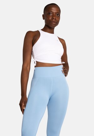 Biały prążkowany crop top z regulowanymi sznureczkami po bokach, w zestawie z jasnoniebieskimi legginsami o wysokim stanie. Gładka tekstura, sportowy design.