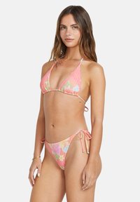 Pink floral print bikini with triangular top and adjustable tie-side bottoms. Features smooth fabric and vibrant colors, including greens and blues.