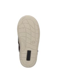 Shoe sole with a textured rubber surface, featuring a white midsole and a black label with "BUNNIES" text near the heel.