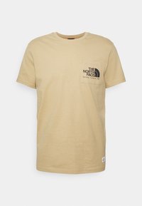 Beige tričko s krátkým rukávem a kulatým výstřihem, s přední kapsou na hrudi, která obsahuje logo "The North Face" a text "Berkeley, California 1966".