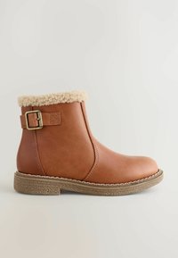 Braune Knöchelschuhe mit Shearling-Manschette, seitlichem Schnallenriemen und strukturiertem GummiSohle, entworfen für Komfort bei kaltem Wetter.