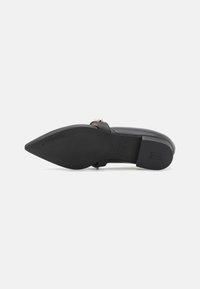 Black leather flat shoe with a pointed toe, featuring a slim strap and gold-tone hardware. Smooth texture with a solid color design.