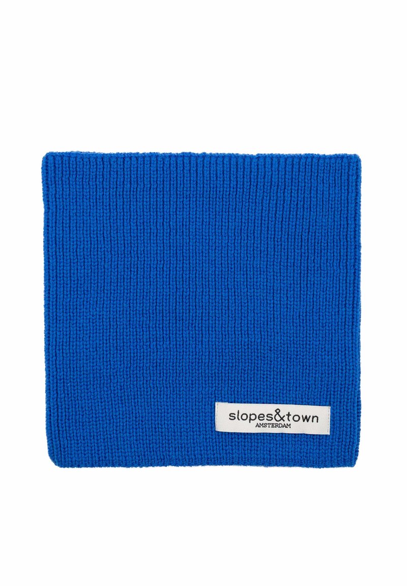 Cache-nez en tricot bleu avec une texture côtelée, arborant une étiquette blanche sur laquelle est inscrit "slopes&town AMSTERDAM." Conçu pour la chaleur et le confort.