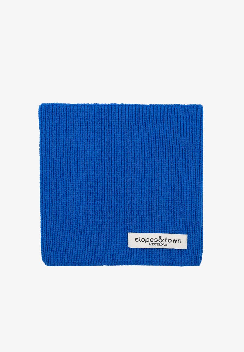 Cache-nez en tricot bleu avec une texture côtelée, arborant une étiquette blanche sur laquelle est inscrit "slopes&town AMSTERDAM." Conçu pour la chaleur et le confort.