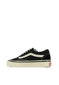 Sneaker nera in tela con dettagli e cuciture bianche. Design a collo basso, punta rotonda, suola in gomma e logo Vans sul tallone.