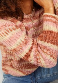 Pletený svetr s pruhovaným vzorem v růžové, krémové a rezavé barvě. Hustá textura s žebrovanými manžetami a kulatým výstřihem.