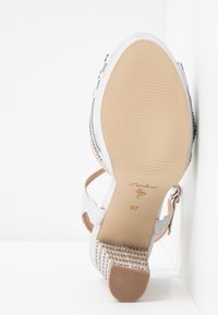 Stříbrné sandály na vysokém podpatku s texturovanou tkaninou, zadním páskem, otevřenou špičkou a béžovou gumovou podrážkou. Velikost 37 je označena na vnitřní podrážce.