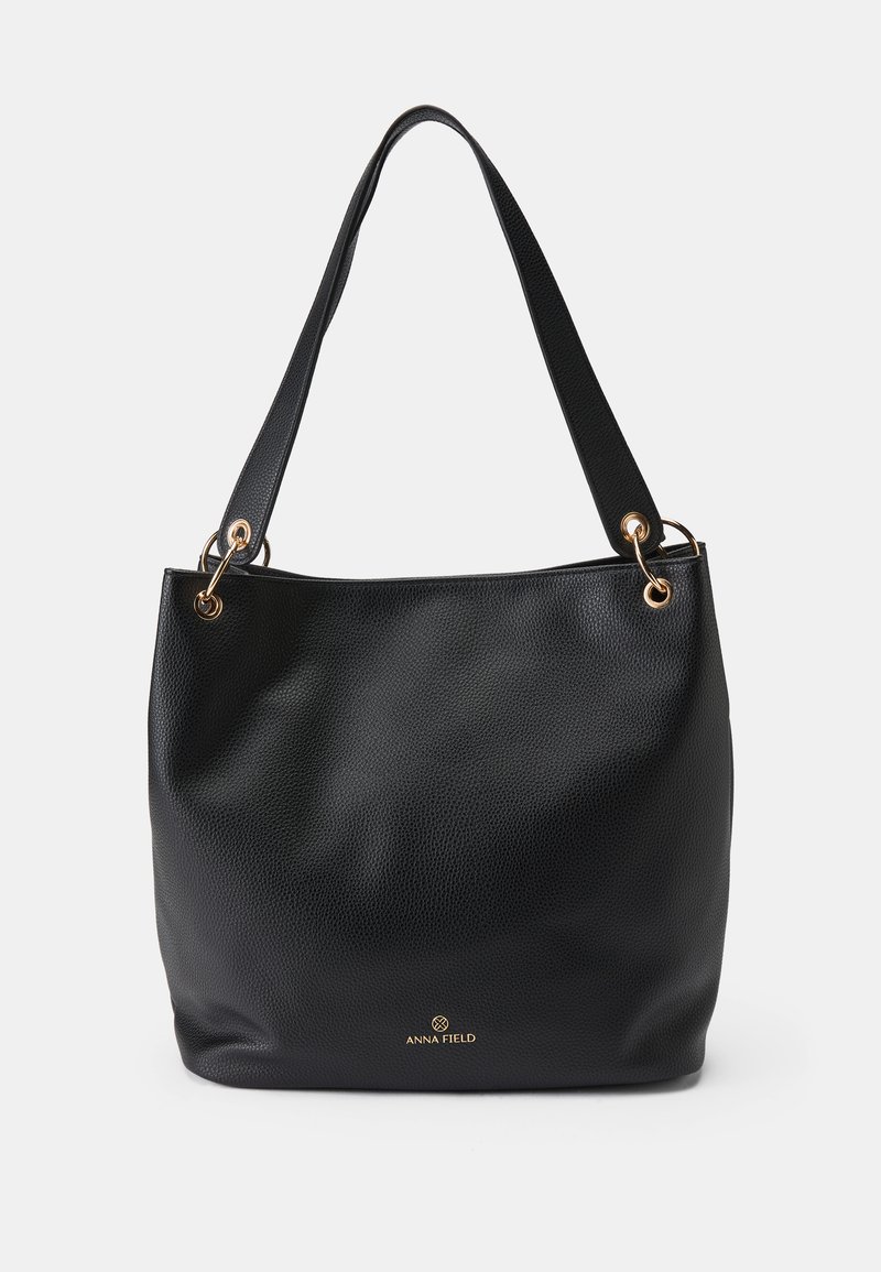 Black leather tote bag with textured surface, two short handles, gold hardware accents, and embossed brand logo at the bottom.