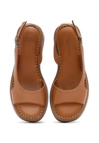 Sandali in pelle marrone con punta aperta, design slingback, dettagli di cucitura e suole piatte. Texture liscia e dettagli di hardware minimi.
