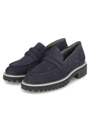 Paire de mocassins en suède bleu marine avec semelles épaisses crantées noires et bout arrondi, présentés côte à côte sur un fond blanc.
