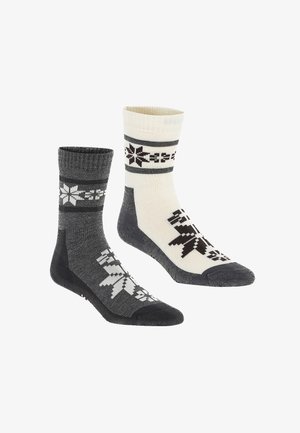 Zwei Paar Crew-Socken: ein Paar grau mit weißem Schneeflockenmuster, das andere in Creme mit schwarzen Akzenten und Schneeflocken. Material aus Baumwollmischung.