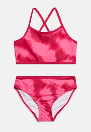 Costum de baie două piese roz și roșu cu imprimeu tie-dye, bretele încrucișate pe partea de sus și slip asortat pe fundal alb.