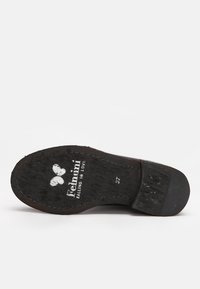 Black rubber shoe sole with textured surface, featuring a butterfly logo and embossed text. Size 37 noted on the bottom.