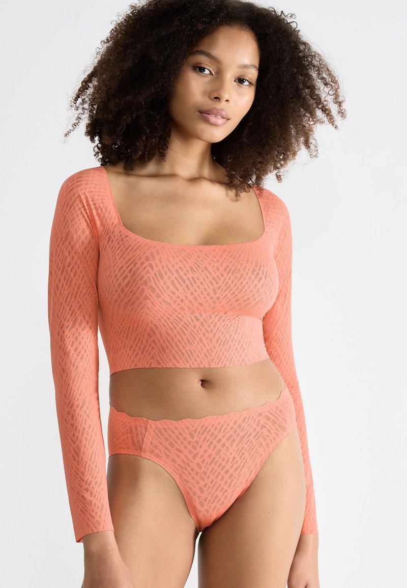 Langärmliges korallenfarbenes Cropped-Top und passende hochgeschnittene Bikinihose, mit einem strukturierten Muster und gewellten Kanten am Taillenbund.