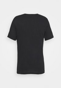 Camiseta negra de manga corta hecha de algodón. Presenta un escote redondo y un dobladillo recto. Diseño minimalista sin logotipos ni patrones visibles.