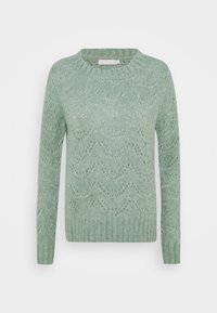 Ljusgrön stickad tröja med rund halsringning. Har ett vågmönster och ribbade muddar och nederkant. Mjuk textur och medium vikt.