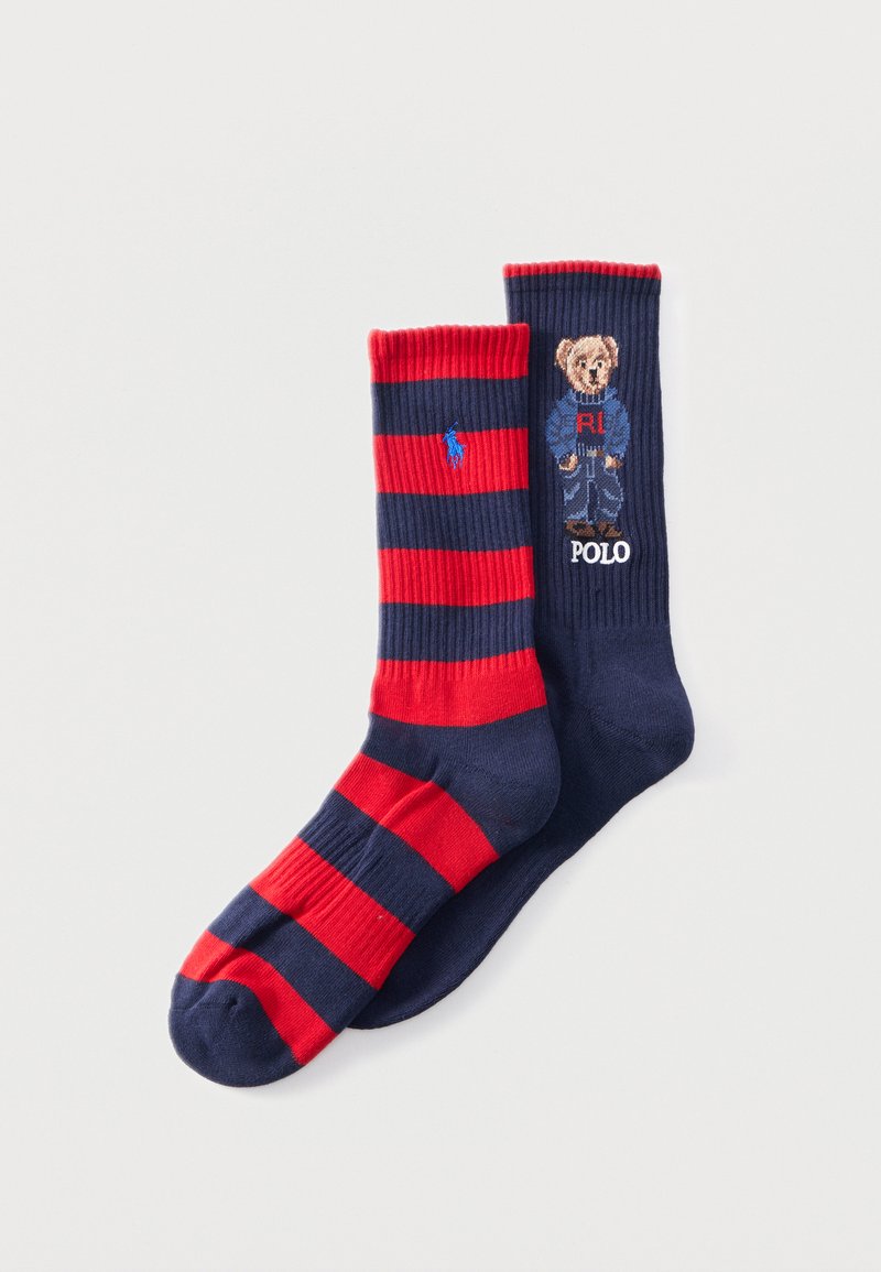 Ζευγάρι κάλτσες με ριγέ σε ναυτικό μπλε και κόκκινο, η μία με λογότυπο μπλε παίκτη πόλο, η άλλη με αρκουδάκι που φοράει μπλε ρούχο και το κείμενο "POLO".