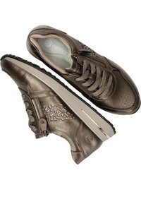 Sneaker métallique marron avec empeigne perforée, accents texturés et fermeture éclair. Dispose d'une semelle épaisse avec une bande contrastante beige.