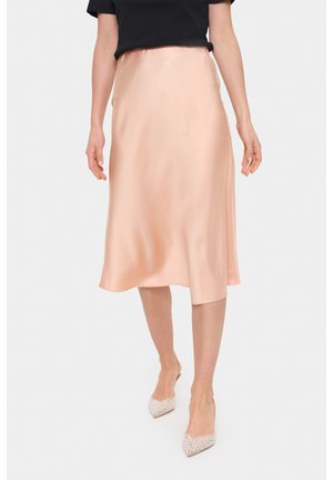 Gonna in satin, lunghezza al ginocchio, di un morbido pesca con una silhouette fluida e un elastico in vita. Abbinata a scarpe scintillanti con punta a punta.