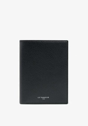 Schwarzes Leder-Reisepassetui mit strukturierter Oberfläche. Am unteren Rand ist der Markenname "LE TANNEUR 1898" geprägt. Rechteckige Form.