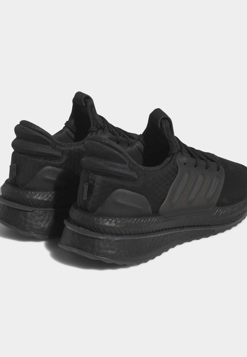 Schwarze Sportschuhe verfügen über ein strukturiertes Obermaterial aus Stoff, flexible Fersenunterstützung und eine gepolsterte Sohle mit einem gewellten Design.