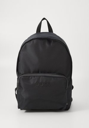 Black backpack made of durable fabric with a rounded shape, featuring a front zip pocket and embossed logo, adjustable straps, and sturdy top handle.
