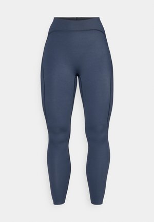 High-waisted leggings in dark navy, made of stretchy fabric, feature seam detailing along the sides for a fitted silhouette.