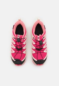 Rosa joggesko har en mesh-overdel, hvite aksenter, elastisk lissesystem og en svart tåhette. Teksturert design og polstret innside.