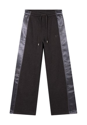 Schwarze Jogginghose mit satinartigen Seiteneinsätzen, elastischem Bund und Kordelzug. Zeigt ein dezentes Logo in Hüfthöhe. Weicher Stoff, weiter Beinschnitt.