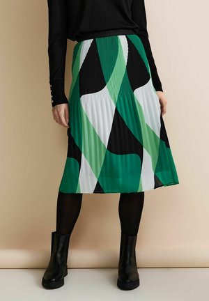 Plisseret midi-nederdel med et dristigt abstrakt mønster i grøn, sort og hvid. Fremstillet af et let materiale med et tætsiddende taljebånd.