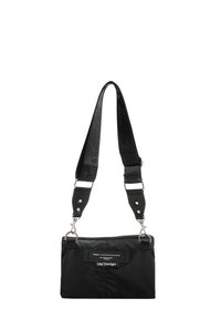 Bolso de hombro negro de nylon con correa ajustable, con herrajes plateados y detalle de etiqueta frontal. Textura suave y forma rectangular.