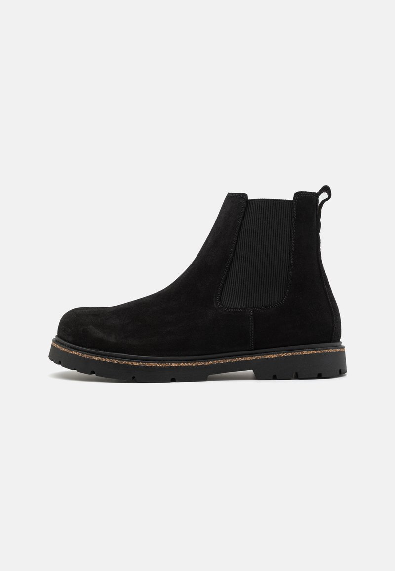 Les bottines chelsea en daim noir présentent des panneaux latéraux élastiques, une semelle en caoutchouc épaisse et une languette pour un enfilage facile. La finition texturée offre une bonne adhérence.