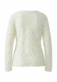 Long-sleeve ivory lace top featuring floral patterns, a round neckline, and a textured fabric with a semi-sheer appearance.