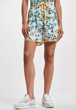 Pantalones cortos de estampado floral en blanco, con patrones de hojas en azul y verde, cintura fruncida con cordón amarillo y ribete amarillo en contraste.